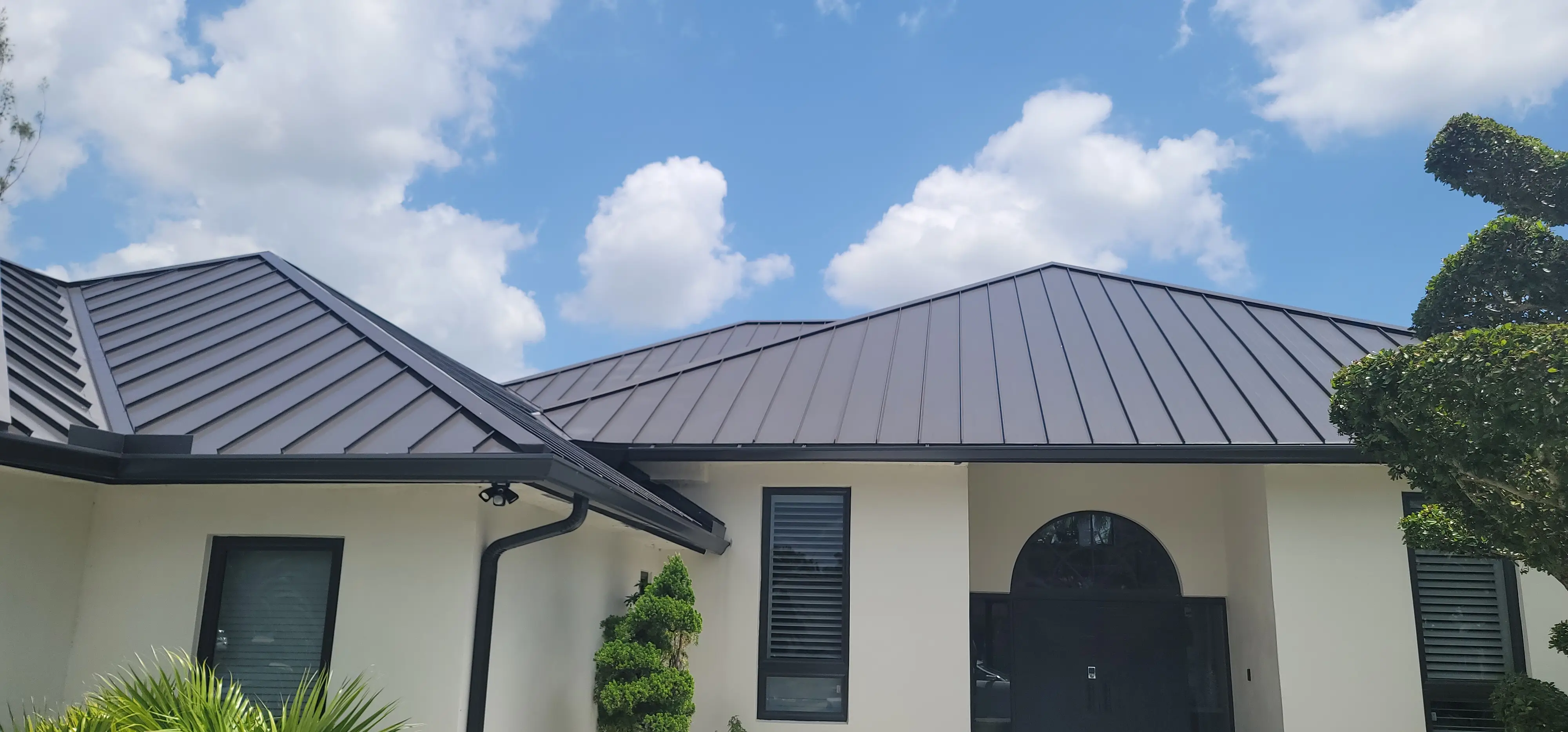 Completed dark standing seam metal roof on a South Florida home