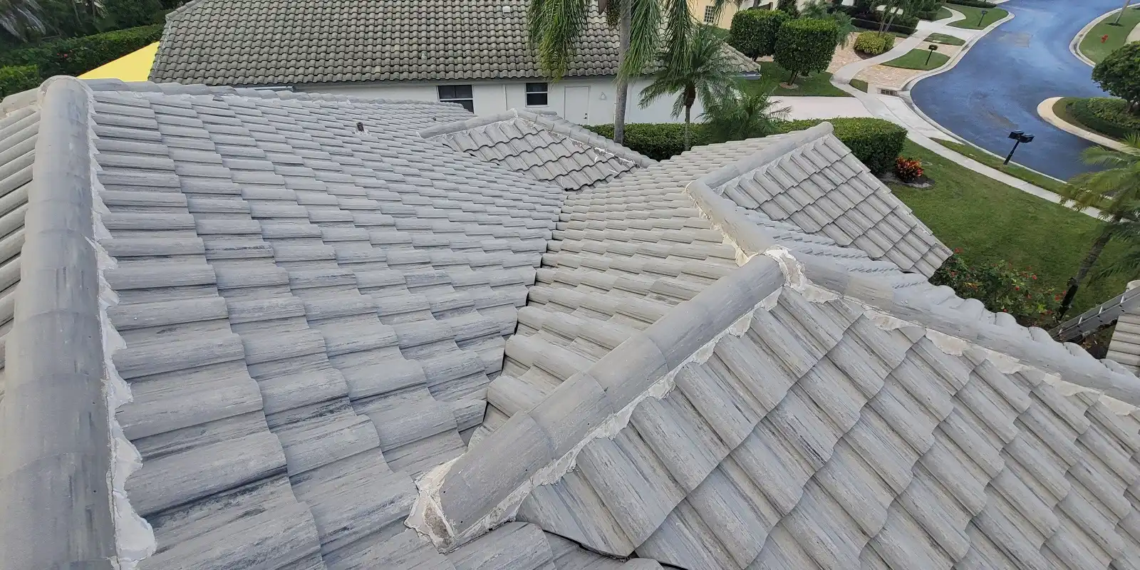 Planet Roofing crew sealing tile valleys and flashing on a new tile roof in Fort Lauderdale FL