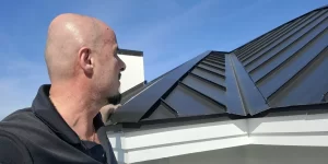 Man inspecting a metal roof