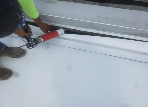 a roofing crew putting Roof Caulking and Sealant to secure a roof installation waterproofing