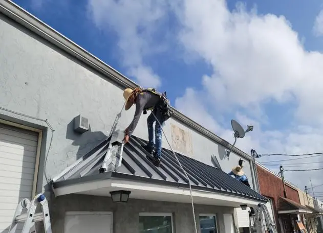 new metal roof installation two people working on top of the roof hired a licensed direct roofing contractor in florida