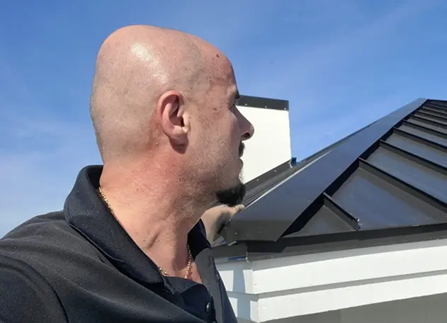 roofing contractor inspecting metal roof