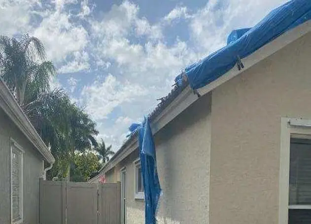 Torn tarp on a roof installed by Planet Roofing, highlighting the need for repair or replacement.