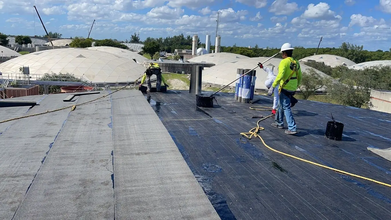 Licensed roofer installing TPO flat roof system on commercial building in Fort Lauderdale