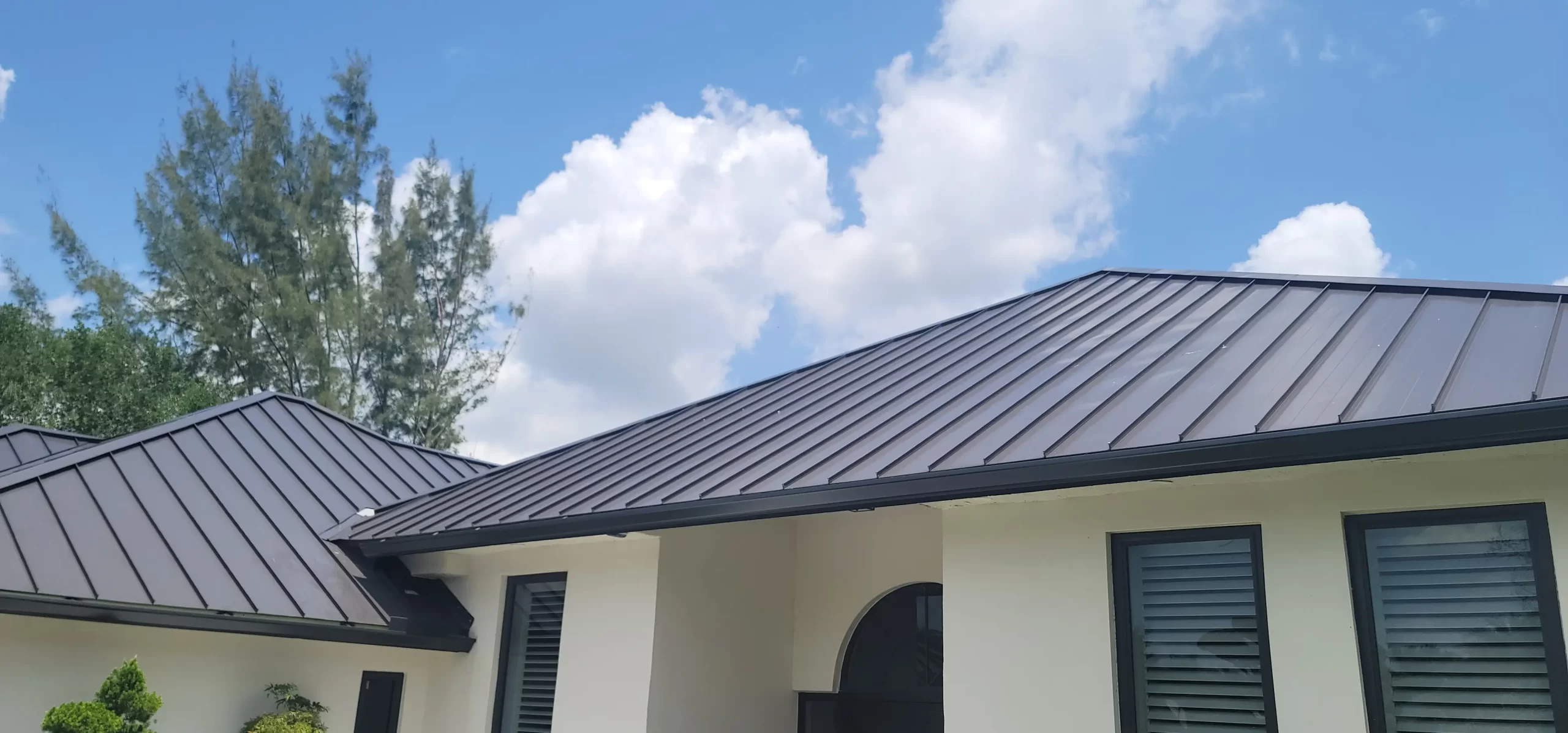 A modern home featuring a sleek standing seam metal roof, promoting energy efficiency